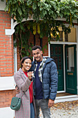 Portrait couple with house keys outside new house