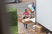 Family moving into new house, carrying belongings