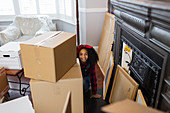 Portrait cute, playful girl among cardboard boxes