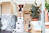 Girl jumping up from behind cardboard boxes