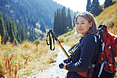 Portrait young photographer backpacking on sunny trail