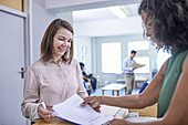 Receptionist helping woman with paperwork