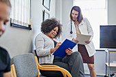 Female doctor and patient discussing paperwork