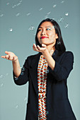 Businesswoman catching falling bubbles