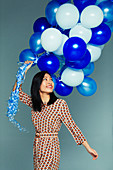 Woman with blue and white balloon bunch
