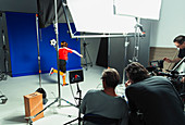 Photographers and teenage girl soccer player in studio