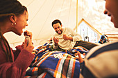 Family playing cards inside camping yurt