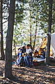 Lesbian couple with kids at campsite in woods