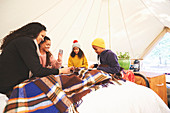 Lesbian couple and kids playing cards in camping yurt