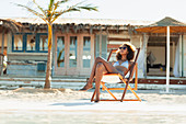 Serene young woman sunbathing on beach