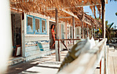 Woman standing in doorway of beach hut