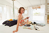 Woman unpacking suitcase on beach house bed