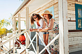 Mother and adult daughter relaxing on beach hut patio
