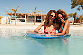 Young women friends with surfboard