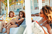 Happy multi-generation women relaxing on beach patio
