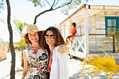 Mother and adult daughter outside beach hut