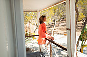 Serene young woman relaxing on beach hut patio