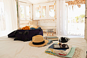 Suitcase, sun hat, sunglasses, book and digital tablet