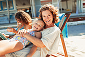 Grandmother and granddaughter relaxing on beach