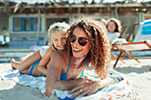 Mother and daughter relaxing on beach