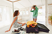 Young women friends unpacking suitcase