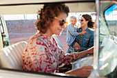 Multi-generation women with map in van