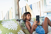 Young woman using digital tablet on beach patio