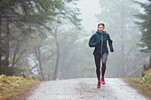 Woman jogging in rainy woods