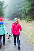 Women with dog hiking in woods