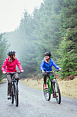 Women mountain biking in woods
