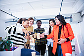 Businesswomen celebrating new office, pouring champagne