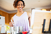 Smiling woman with cookbook cooking