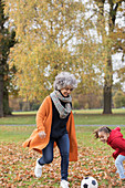 Playful grandmother playing soccer with granddaughter
