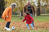 Grandparents playing soccer with granddaughter