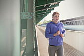 Dedicated woman running along sunny train station platform