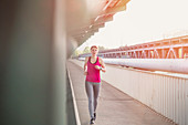 Young woman running on urban train station platform