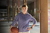 Portrait young woman with basketball