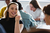 Happy, student talking with classmate in classroom