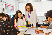 Female teacher helping student studying at table