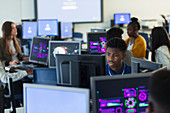 Focused boy student using computer in dark computer lab
