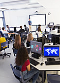 Students at computers listening to teacher