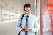 Businessman using digital tablet in train station