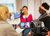 Video camera filming community college journalism students