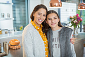 Portrait happy mother and daughter hugging in kitchen