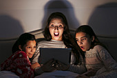 Surprised mother and daughters watching movie