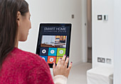 Woman using smart home automation system with tablet
