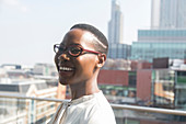 Happy businesswoman on sunny, urban balcony