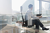 Businessman working in sunny, urban office