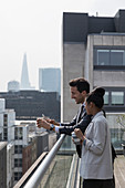 Business people talking on sunny, urban balcony