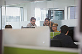 Business people meeting at computer in open plan office